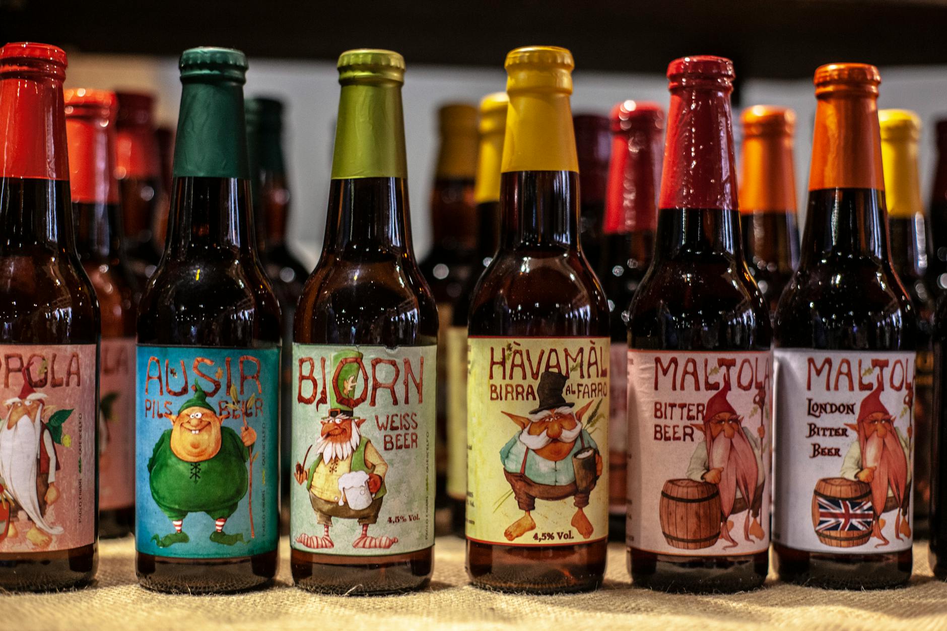 Butelki rzemieślniczego piwa z kolorowymi, różnorodnymi etykietami