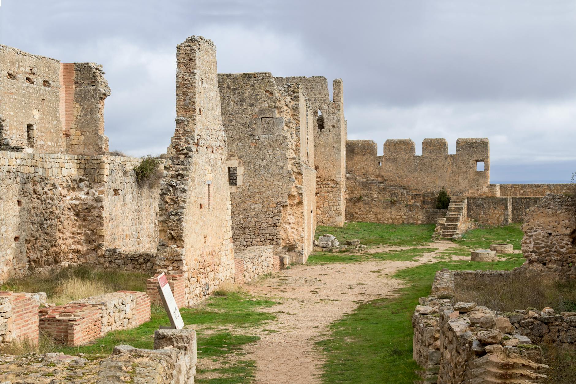 Kamienne ruiny zamku na wzgórzu w słonecznym krajobrazie