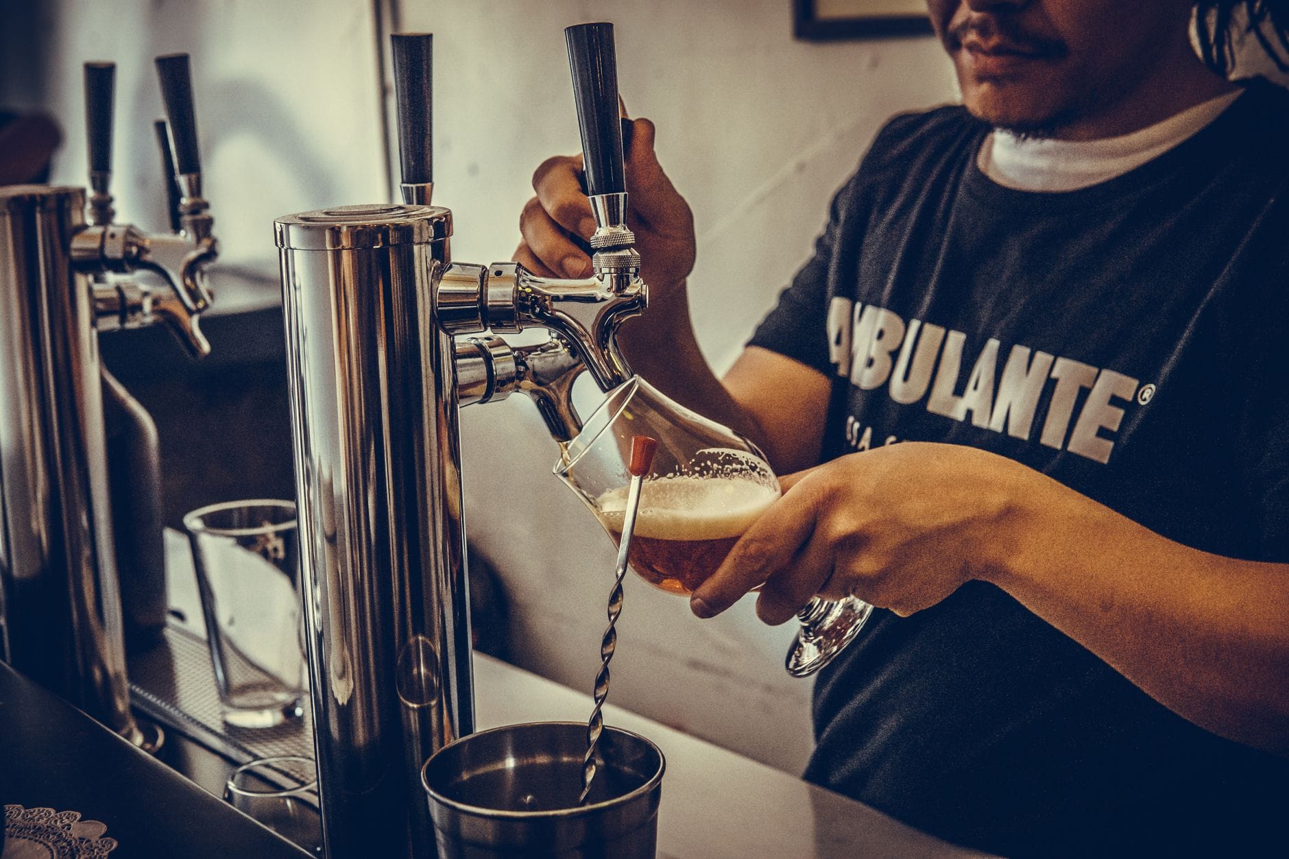 Barman nalewa rzemieślnicze piwo z kranu w multitapie