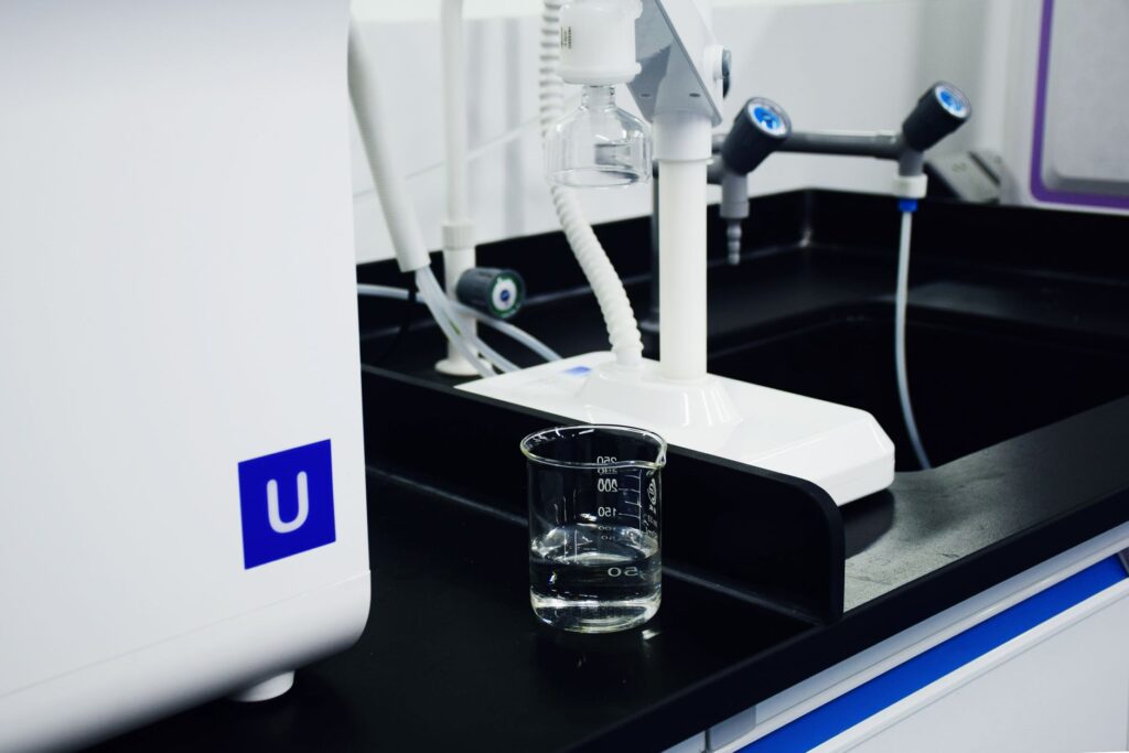 Zbliżenie na zlewkę i aparaturę laboratoryjną w nowoczesnym laboratorium
