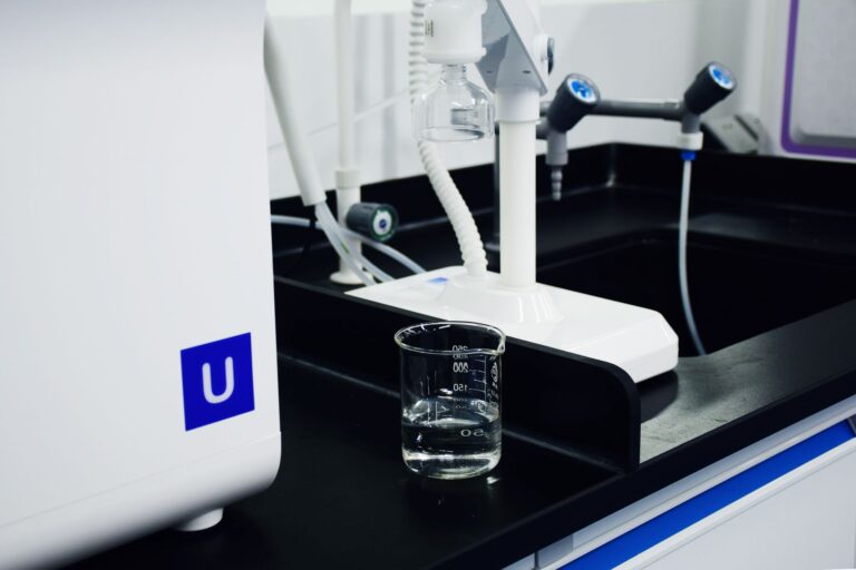 Zbliżenie na zlewkę i aparaturę laboratoryjną w nowoczesnym laboratorium